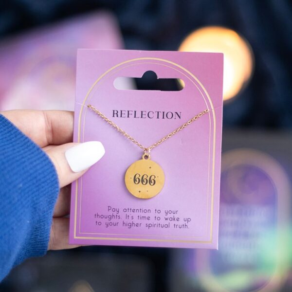 A hand holds a gold necklace with the number "666" on a purple card labeled "Reflection."