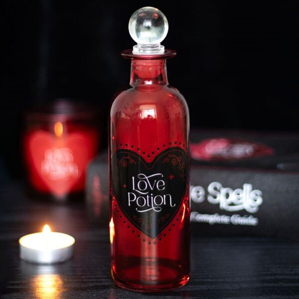 A decorative red bottle labeled "Love Potion" sits beside a candle and spell book.