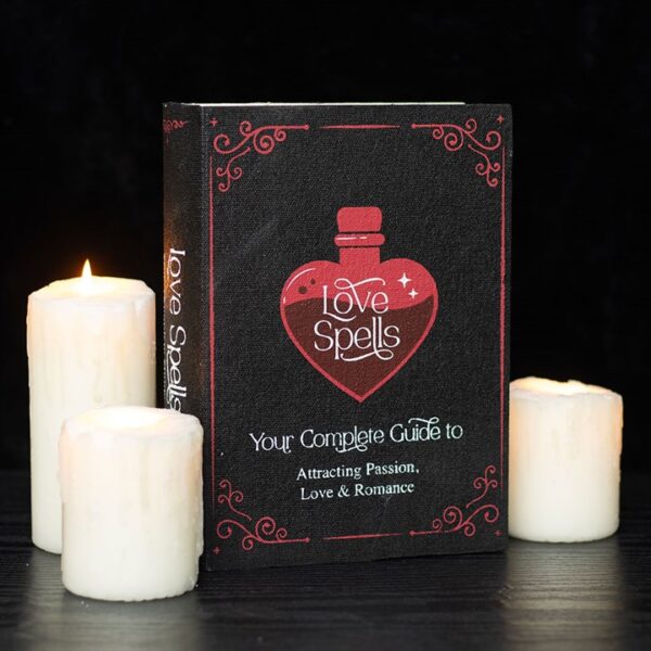 A book titled "Love Spells" surrounded by three lit candles, focusing on attraction and romance.