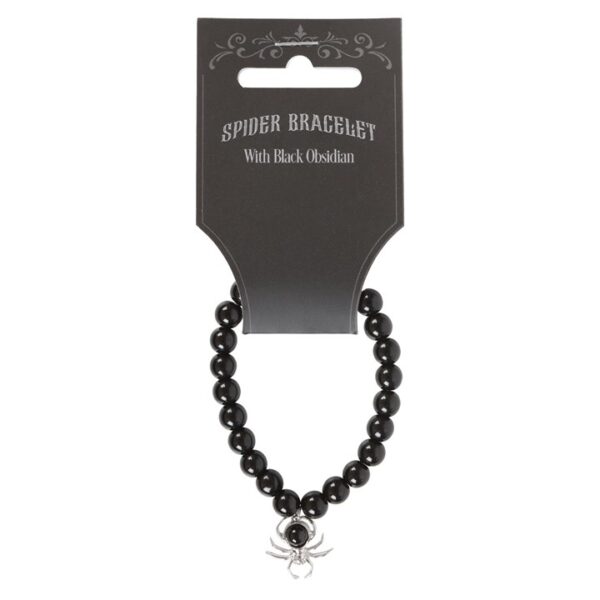 A black obsidian spider bracelet displayed on a tag, featuring shiny beads and a silver charm, 1740507541.