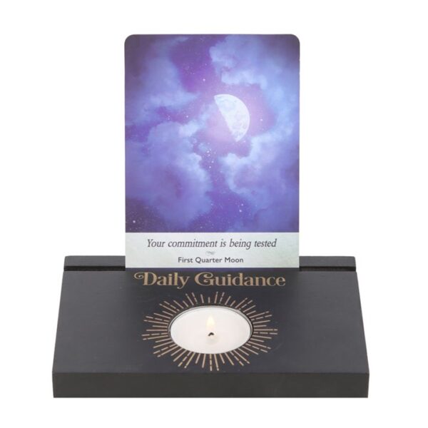 A crystal holder displays a card with a moon illustration, conveying daily guidance about commitment.