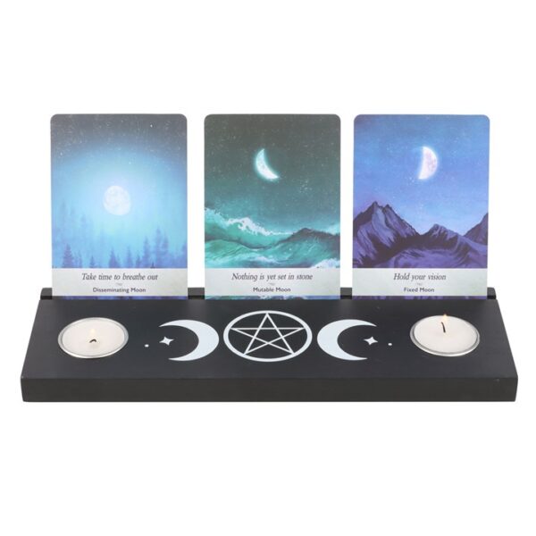 A decorative candle holder featuring three cards with moon phases and affirmations for spiritual reflection.