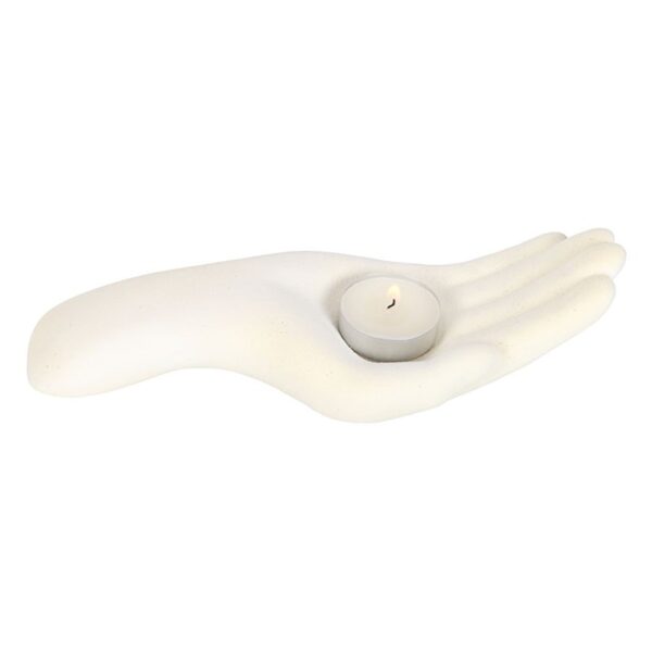 A decorative white hand-shaped candle holder cradles a small lit tealight candle.